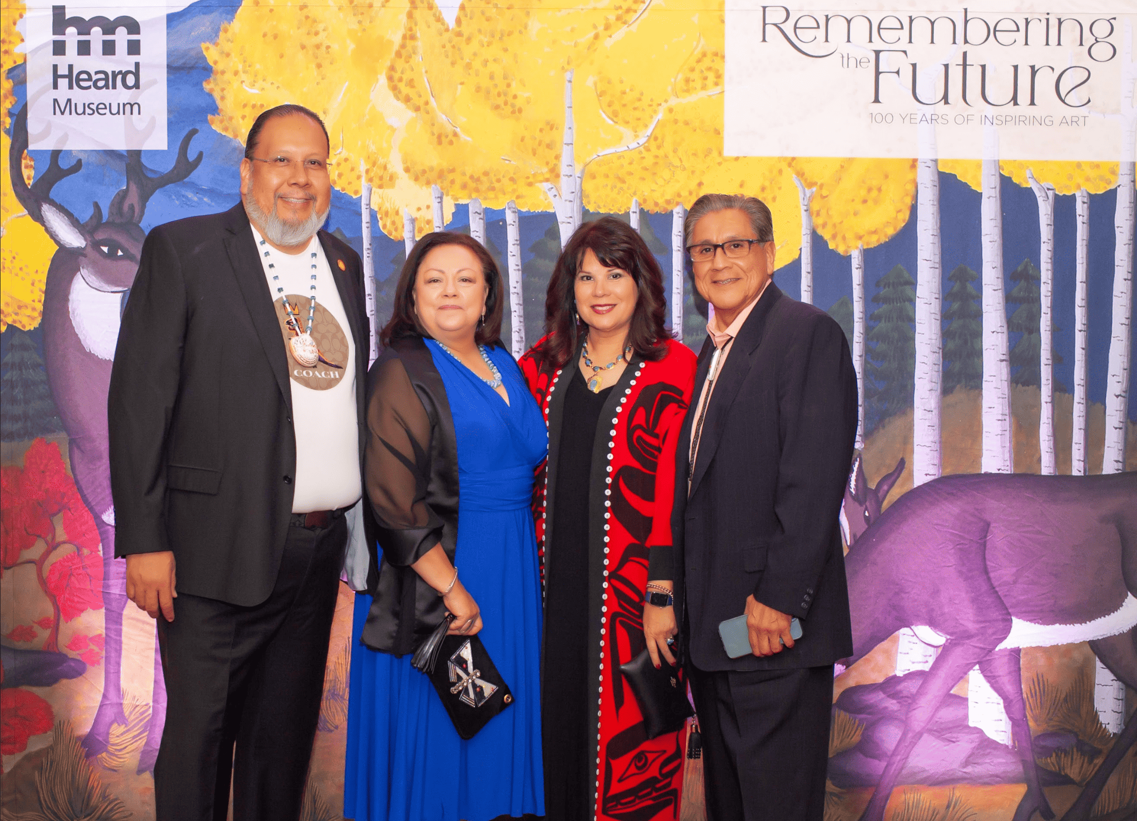 Four people dressed in formal attire posing together at the moondance event called "remembering the future: 100 years of inspiring art" at the Heard Museum.