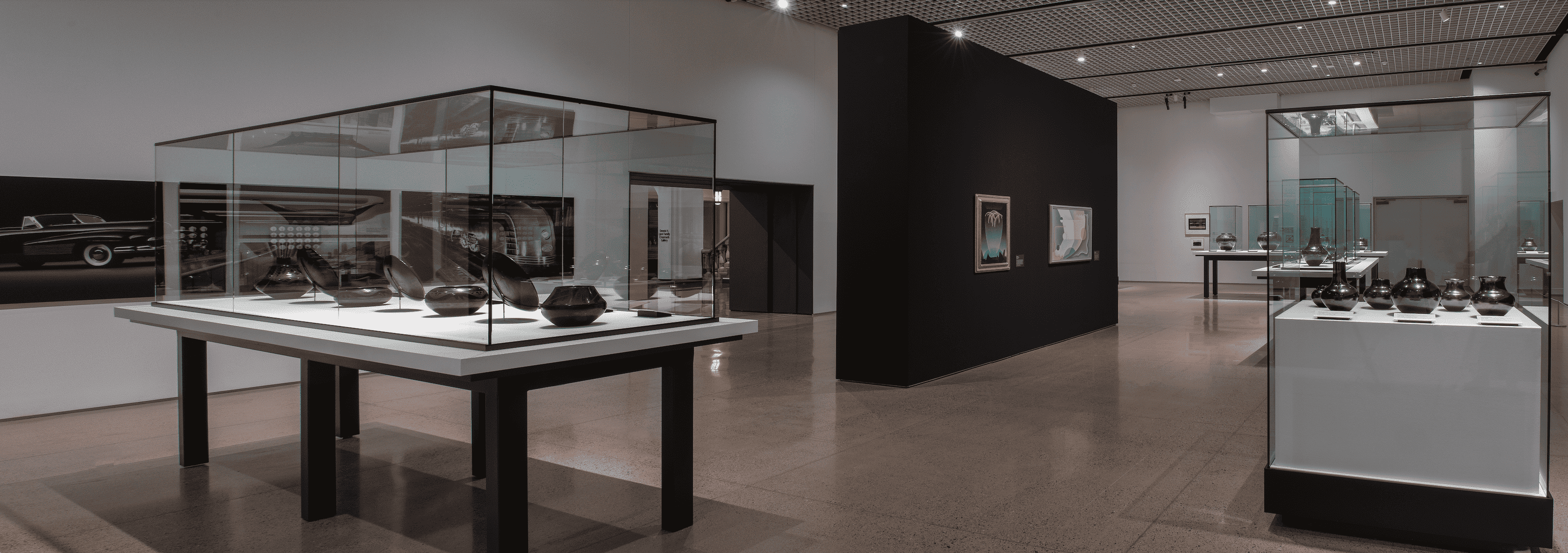 Modern art exhibit featuring a collection of glass pieces displayed in a well-lit gallery space.