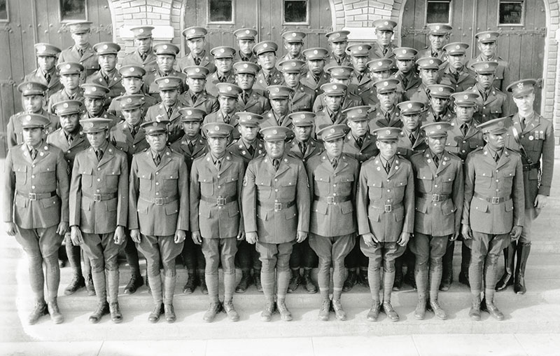 1930 black and white photo of young Native men in military uniforms posing on steps