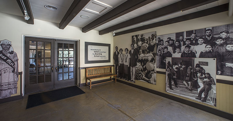 Covered porch entry with photographic images of Native American youth on the walls.