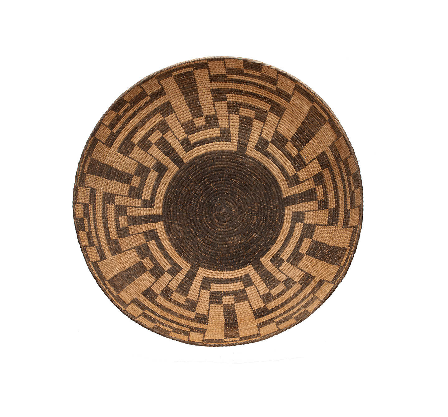 A round, woven basket with intricate geometric patterns in brown and tan colors, viewed from above.