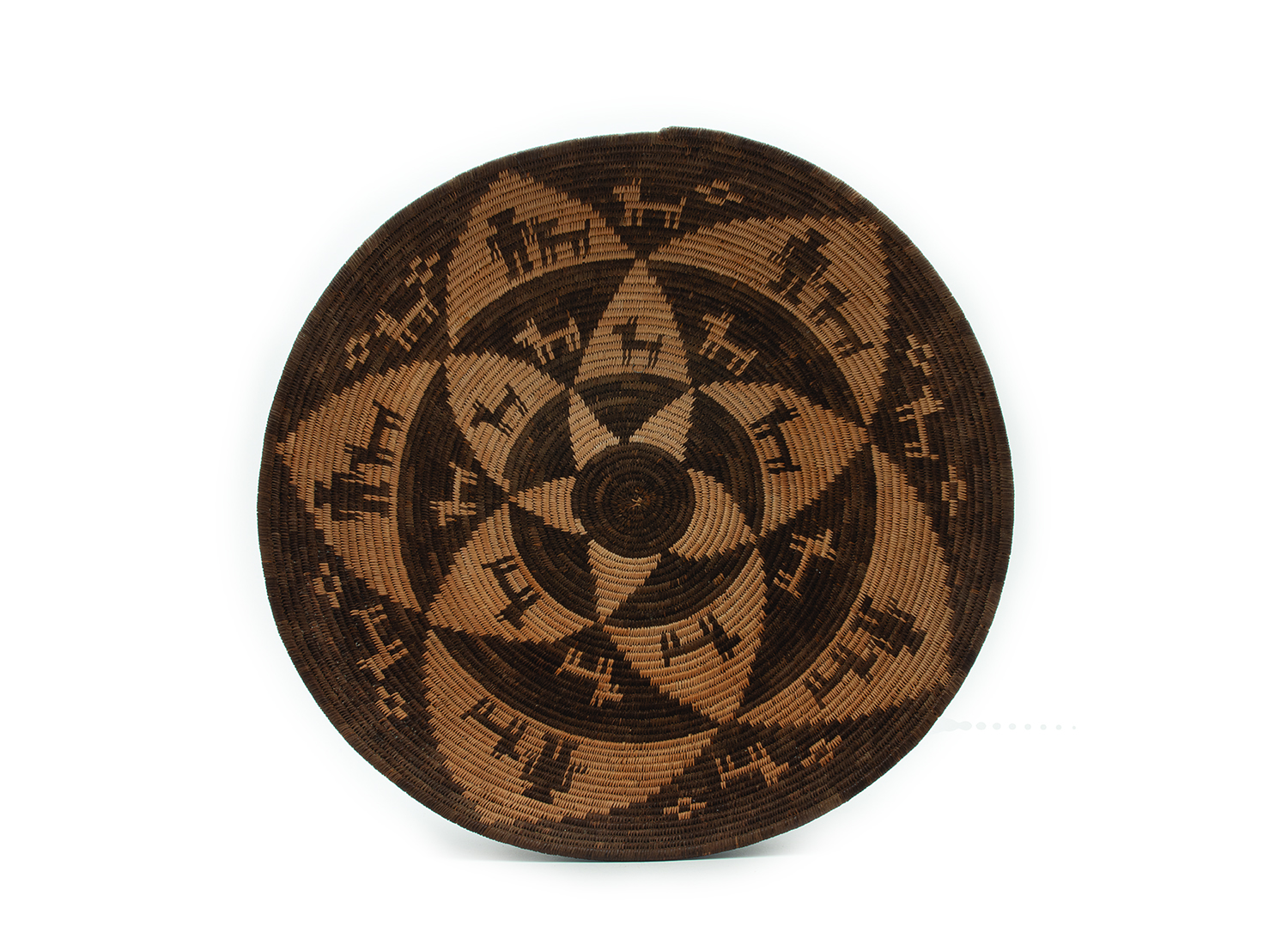 A round woven basket with a geometric pattern of interlocking triangles and abstract shapes, using various shades of brown.