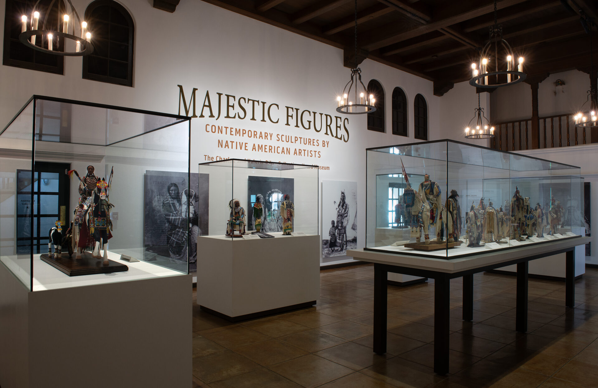 Exhibit room featuring Native American sculptures displayed in glass cases. The sign reads, "Majestic Figures: Contemporary Sculptures by Native American Artists.