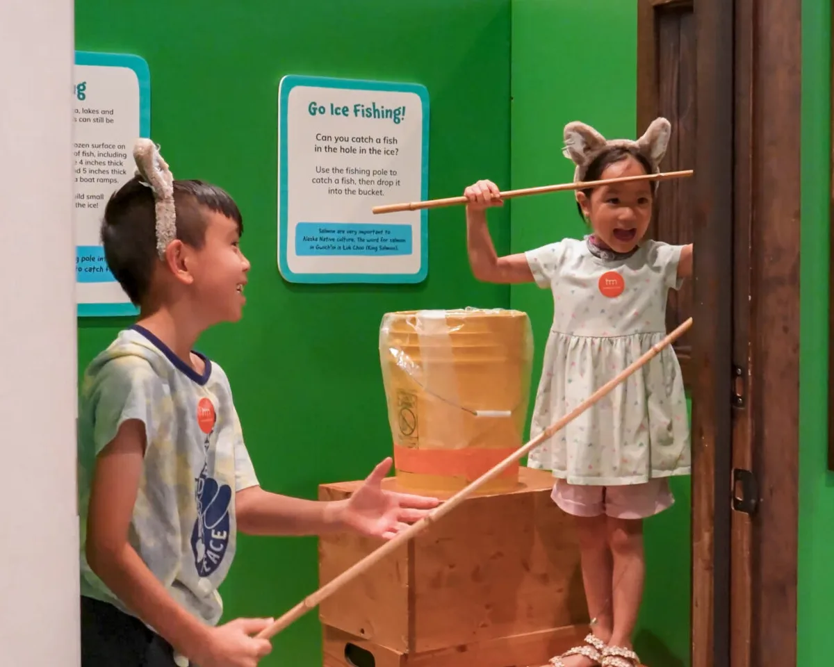 Two children playing in a pretend ice fishing activity