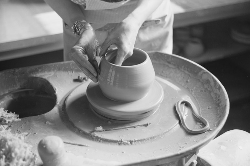1940s black and white photo detail of pottery being shaped on a pottery wheel