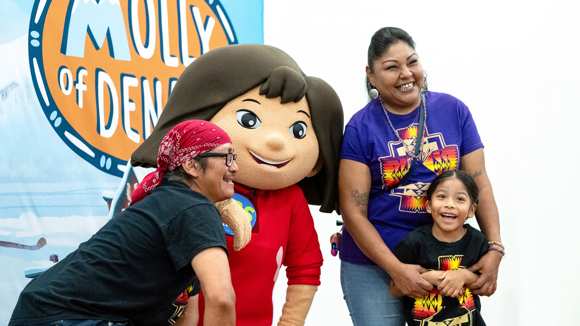 A family poses for a photo with Molly from Molly of Denali