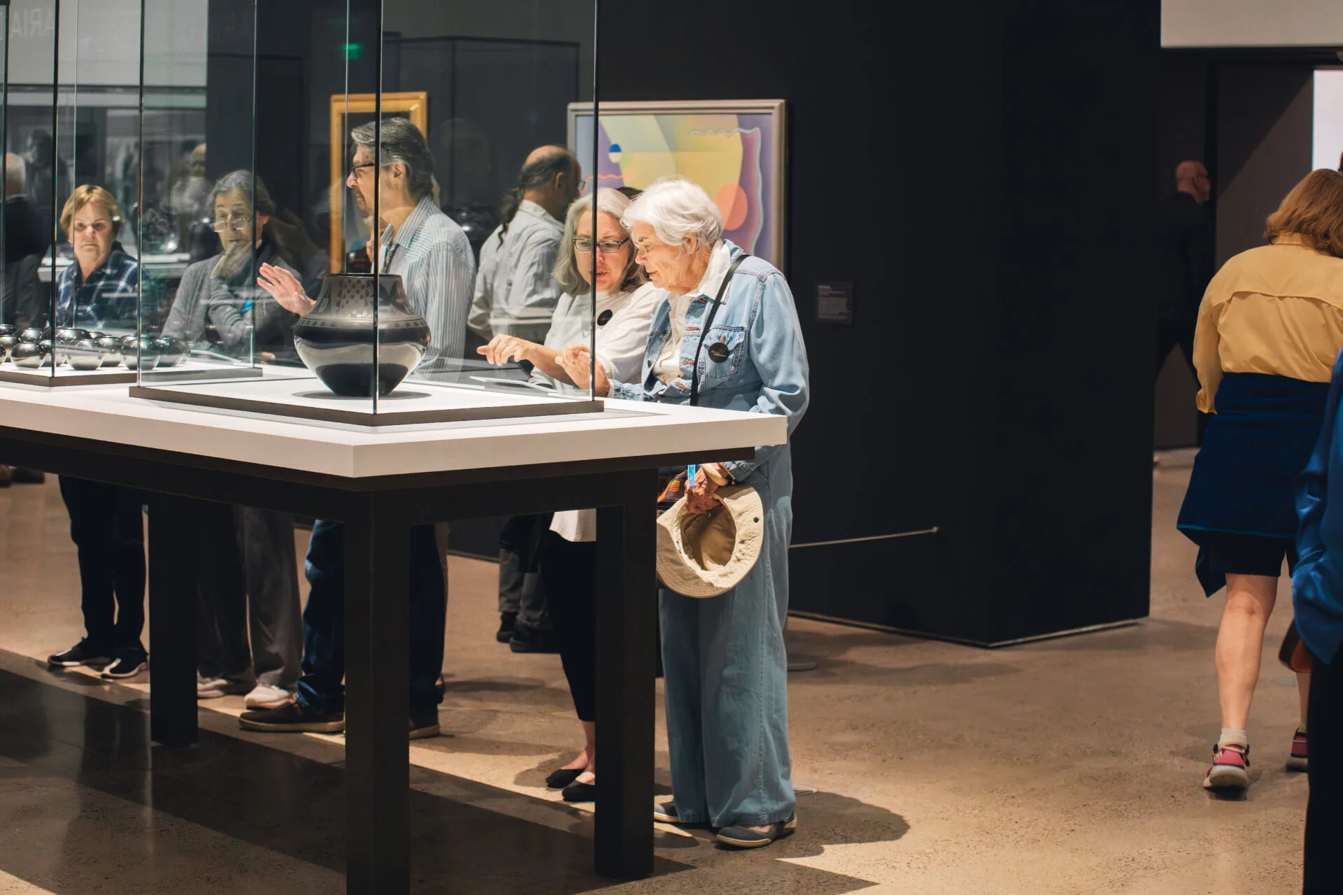 Adults browse the glass display cases at the Heard